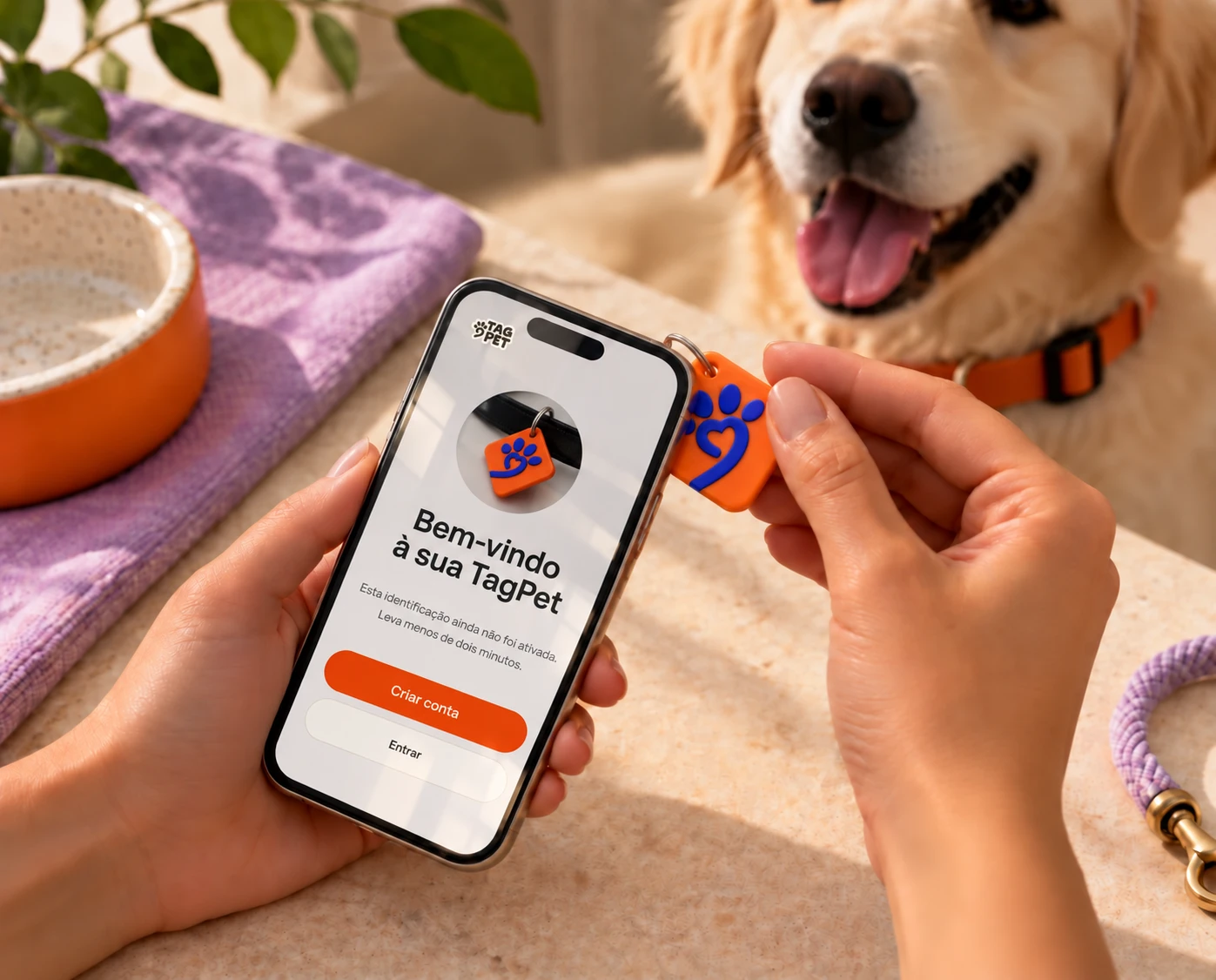 Tutor aproximando a TagPet do celular, que abre a tela de boas-vindas para ativar a identificação, com um golden retriever ao fundo